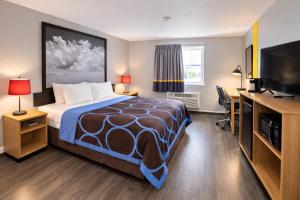 a hotel room with a bed and a desk at Super 8 by Wyndham Lewiston in Lewiston