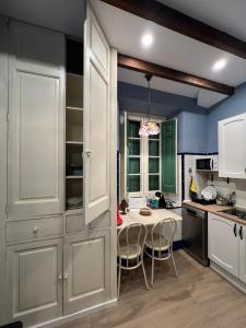 a kitchen with white cabinets and a table with chairs at Casa Aguilar-Habitaciónes y más en casa exclusiva en Centelles in Centellas