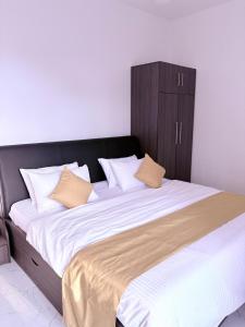 a large bed with a black headboard and white sheets at Edelweiss Living Negombo in Negombo
