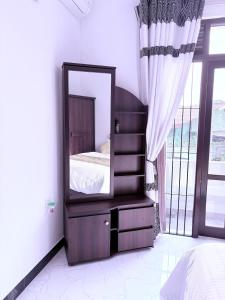 a mirror sitting on a dresser in a bedroom at Edelweiss Living Negombo in Negombo +13 photos