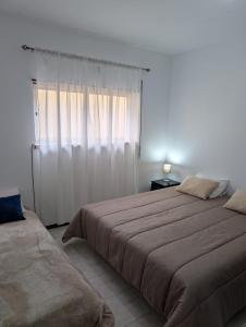 a bedroom with a large bed and a window at Cozy rooms in Minde, Fatima in Minde