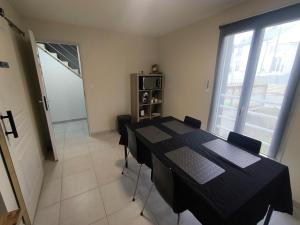a dining room with a black table and chairs at Notre Dame d'Orgemont - Marron 6 in Argenteuil