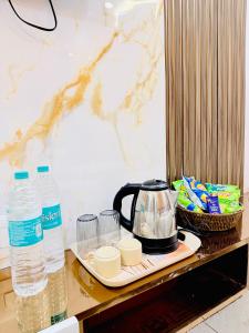 a tea kettle on a tray on a counter with water at Hotel Hira Palace in Ujjain