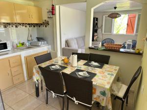 a dining room table with chairs and a kitchen at L'île au Vert in Gros-Morne