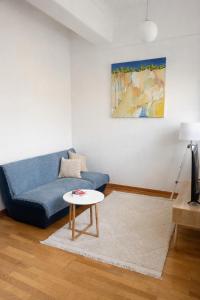 a living room with a blue couch and a table at Luxury Historic City-Centre Flat & Free Parking in Glasgow