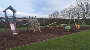 a park with a playground with a slide and a bench at Le pas de la Fagne in Sprimont