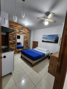 a bedroom with a bed and a ceiling fan at Hotel Condina Pereira in Pereira