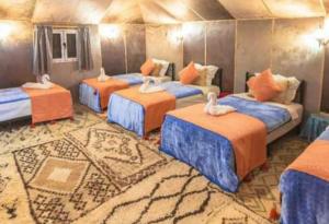 a room with four beds with white swans on them at Sahara Imperial Luxury Camp in Merzouga +21 photos