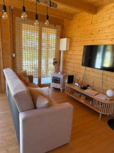 a living room with a couch and a flat screen tv at Retiro Sereno in Cadaval