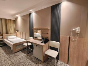 a room with a bed and a desk and a bed and a bedroom at Pensione Antonio - Klimatyzowane Pokoje, Centrum Słupska, Spokojny Hotel in Słupsk