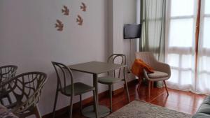 a room with a table and chairs and a tv at Céntrico apartamento en el casco antiguo de Potes in Potes