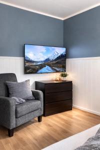 a living room with a couch and a tv on a wall at Kristiansund Airport Motell in Kristiansund
