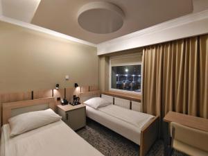 a hotel room with two beds and a window at Pensione Antonio - Klimatyzowane Pokoje, Centrum Słupska, Spokojny Hotel in Słupsk