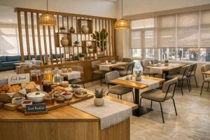 a restaurant with tables and chairs with food on display at Hotel Simos in Mitika