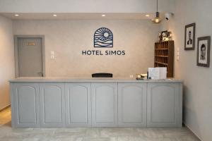 a hotel shngos sign on a wall in a room at Hotel Simos in Mitika