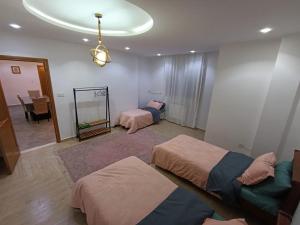 a room with three beds and a mirror in it at Jolie appartement avec terrasse in Reghaïa