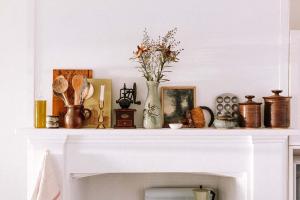 a white fireplace mantle with a vase of flowers on it at Ateliers Den in Beechworth