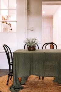 a green table with chairs and a vase of flowers on it at Ateliers Den in Beechworth +63 photos