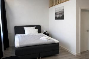 a bedroom with a bed with a black headboard at MIILOX Apartments Chemnitz Hainstrasse in Chemnitz