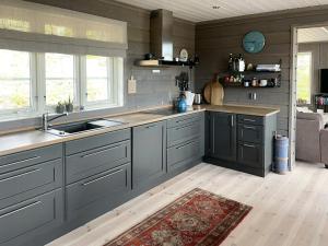 a kitchen with gray cabinets and a sink and a rug at Cabin With Panoramic Views Over The Mountains in Nesbyen