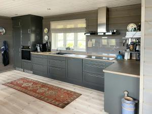 a kitchen with gray cabinets and a rug at Cabin With Panoramic Views Over The Mountains in Nesbyen