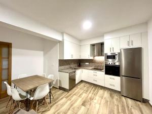 a kitchen with white cabinets and a table and chairs at CAMIÑO DA PRATA in Redondela