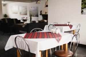 a dining room with white tables and chairs with a table cloth at Pod Limbami in Poronin