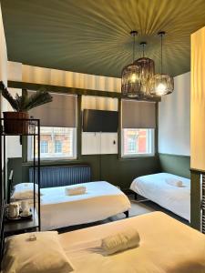 a bedroom with two beds and two chandeliers at Piccadilly Central in Manchester