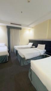 a row of beds in a hotel room at شعيل ان للشقق المخدومة - اقتصادي in Mecca