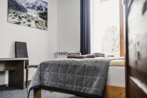 a bedroom with a bed with a blanket on it at Pod Limbami in Poronin