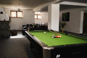 a living room with a pool table and a couch at Pod Limbami in Poronin