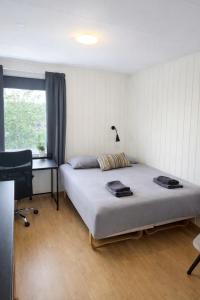 a bedroom with a bed and a desk and a window at Kristiansund Airport Motell in Kristiansund