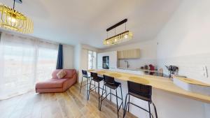 a kitchen with a bar with chairs and a couch at "HORIZON BLEU" - en bord de Mer in Port-de-Bouc