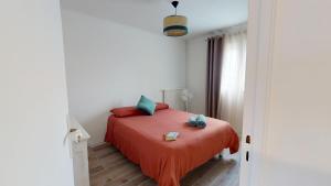 a bedroom with a bed with red sheets and green pillows at "HORIZON BLEU" - en bord de Mer in Port-de-Bouc