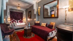 a living room with a bed and a mirror at Riad Sultan Suleiman & Spa in Marrakesh
