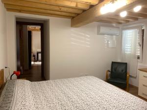 ein Schlafzimmer mit einem Bett und einem schwarzen Stuhl in der Unterkunft Centrocitta' in Carpi + 20 Fotos