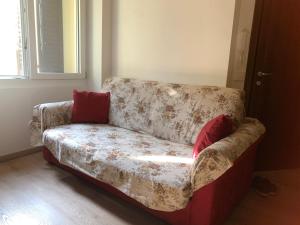 Eine Couch mit roten Kissen im Wohnzimmer. in der Unterkunft Centrocitta' in Carpi