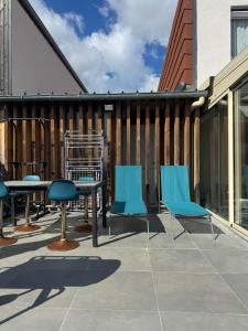 a patio with blue chairs and a table at DAKEY home - Disneyland Paris, Village Nature in Magny-le-Hongre