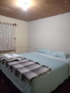 a bedroom with a bed with a blanket on it at Casa Mary in Panajachel