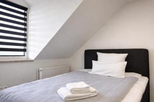 a bedroom with a bed with two towels on it at MIILOX Apartments Chemnitz Hainstrasse in Chemnitz +27 photos