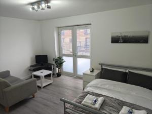 a bedroom with a bed and a chair and a television at Thames Riverside Studio, Gravesend Town Centre - near train station in Gravesend