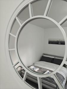 a round mirror in a room with a bed at Thames Riverside Studio, Gravesend Town Centre - near train station in Gravesend