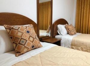 a hotel room with two beds and a mirror at Hostal Chaska Inn in San Antonio