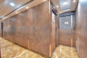 a row of wooden doors in a room with marble floors at Collection O Aafreen Tower Near St. Thomas's Church in Kolkata