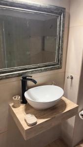 a bathroom with a large white sink on a wooden counter at Rincón del Agreste in Neuquén +5 photos