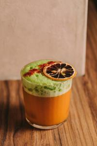 a drink with an orange slice on a wooden table at Hotels 705 O'Porto Hotel in Porto