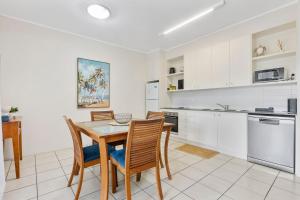 a kitchen with a dining room table and chairs at Baden 74 Rainbow Shores in Rainbow Beach