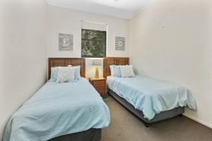 a bedroom with two beds and a window at Baden 74 Rainbow Shores in Rainbow Beach +6 photos
