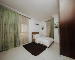 a bedroom with a bed and a large window at AvonHeights Apartments in Lekki Phase 1