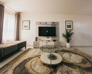 a living room with a couch and a tv at AvonHeights Apartments in Lekki Phase 1